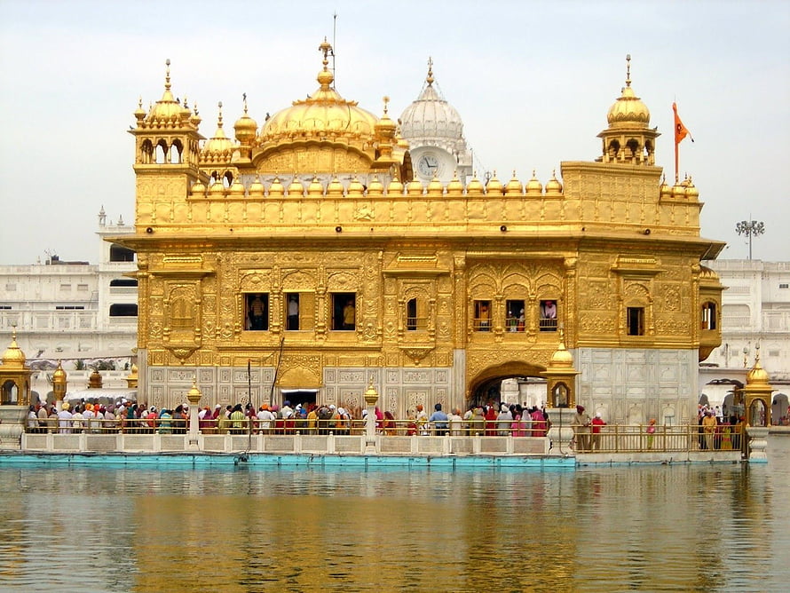 Harmandir Sahib Golden Temple in Amritsar with pilgrims gathered at the sacred water tank HD wallpaper