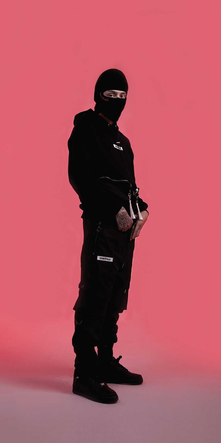 Central Cee in all-black streetwear outfit with balaclava against pink studio backdrop HD phone wallpaper