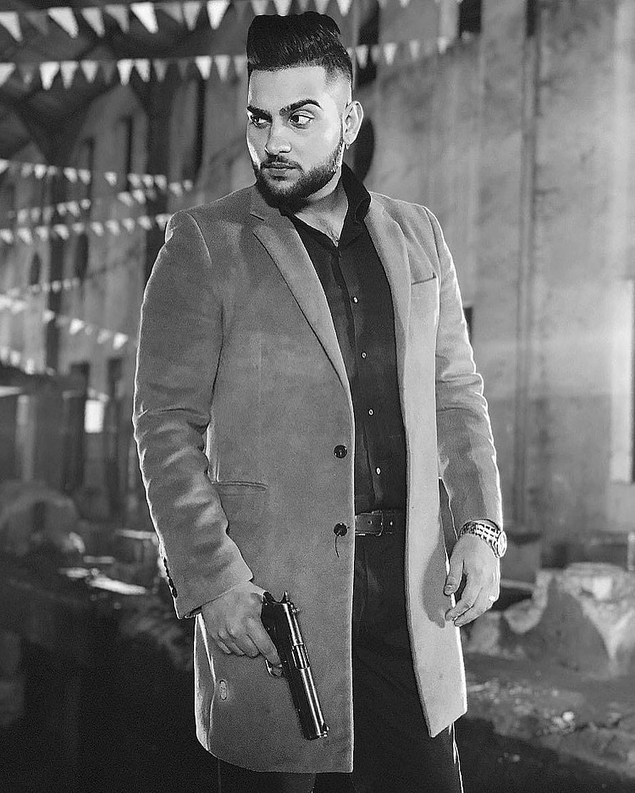 Karan Aujla in a tailored coat holding a pistol in a gritty black and white portrait HD phone wallpaper