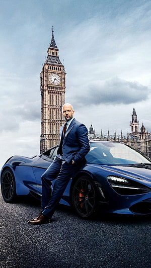 Jason Statham in a blue suit leaning on a McLaren supercar with Big Ben and the Palace of Westminster in London HD phone wallpaper