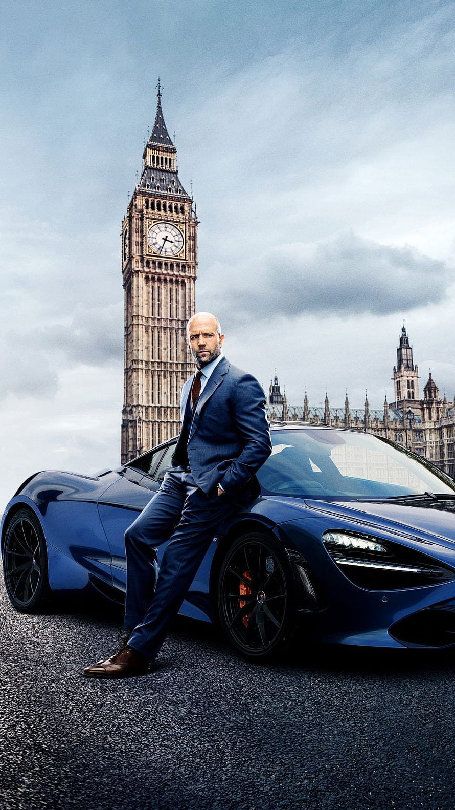 Jason Statham in a blue suit leaning on a McLaren supercar with Big Ben and the Palace of Westminster in London HD phone wallpaper