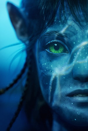Close-up of a blue-skinned Na'vi character with glowing green eyes from the Avatar film series HD phone wallpaper