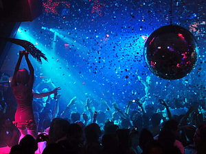 Vibrant nightclub scene with confetti, disco ball, and energetic crowd under blue and pink lights HD wallpaper