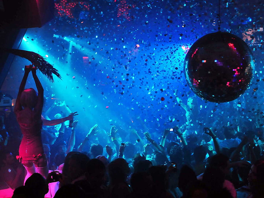 Vibrant nightclub scene with confetti, disco ball, and energetic crowd under blue and pink lights HD wallpaper