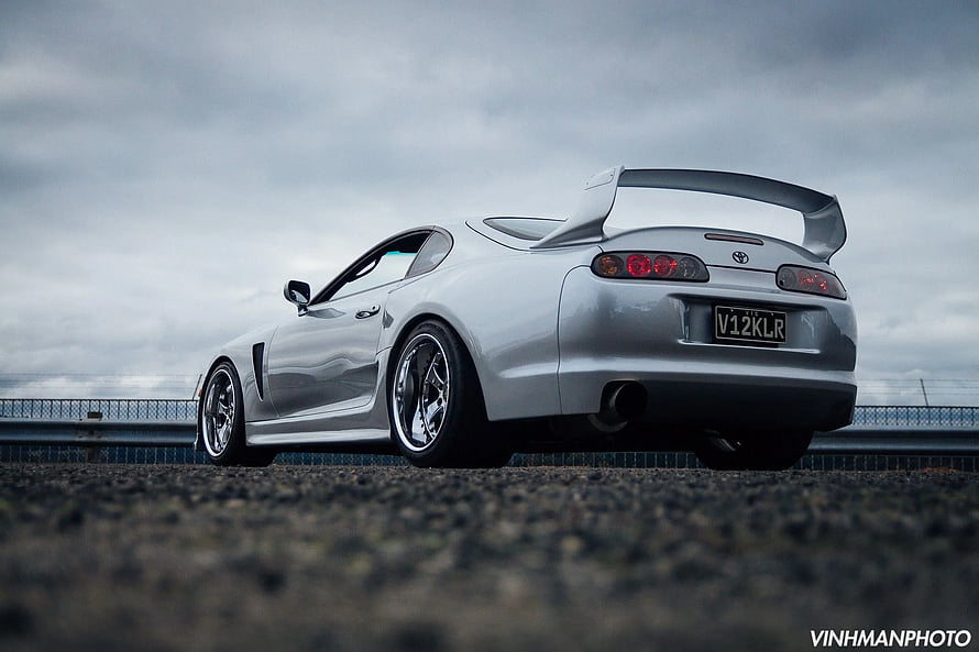Silver Toyota Supra Mk4 Rear Three-Quarter View on Gravel Track Under Overcast Sky HD wallpaper
