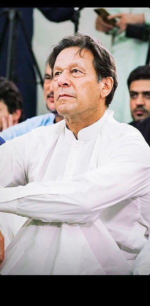 Imran Khan in a white shalwar kameez with arms crossed at a public event HD phone wallpaper