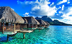 Tropical Overwater Bungalows With Thatched Roofs On Turquoise Lagoon HD wallpaper