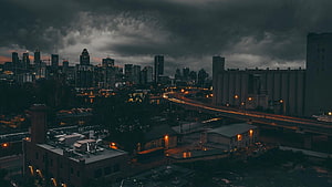 Montreal skyline at dusk with dramatic storm clouds and illuminated highway traffic HD wallpaper