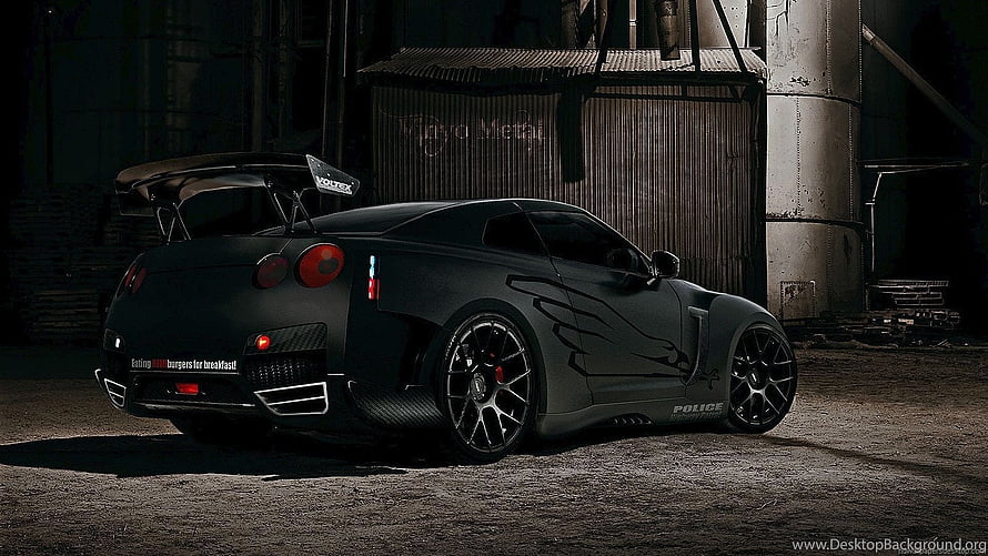 Matte Black Nissan GT-R R35 Widebody with Vortex Wing in Industrial Setting HD wallpaper