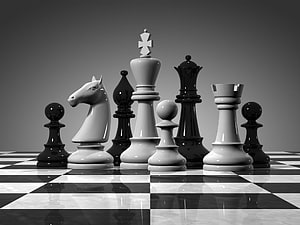 Monochrome Chess Pieces Arranged on a Reflective Checkered Board HD wallpaper