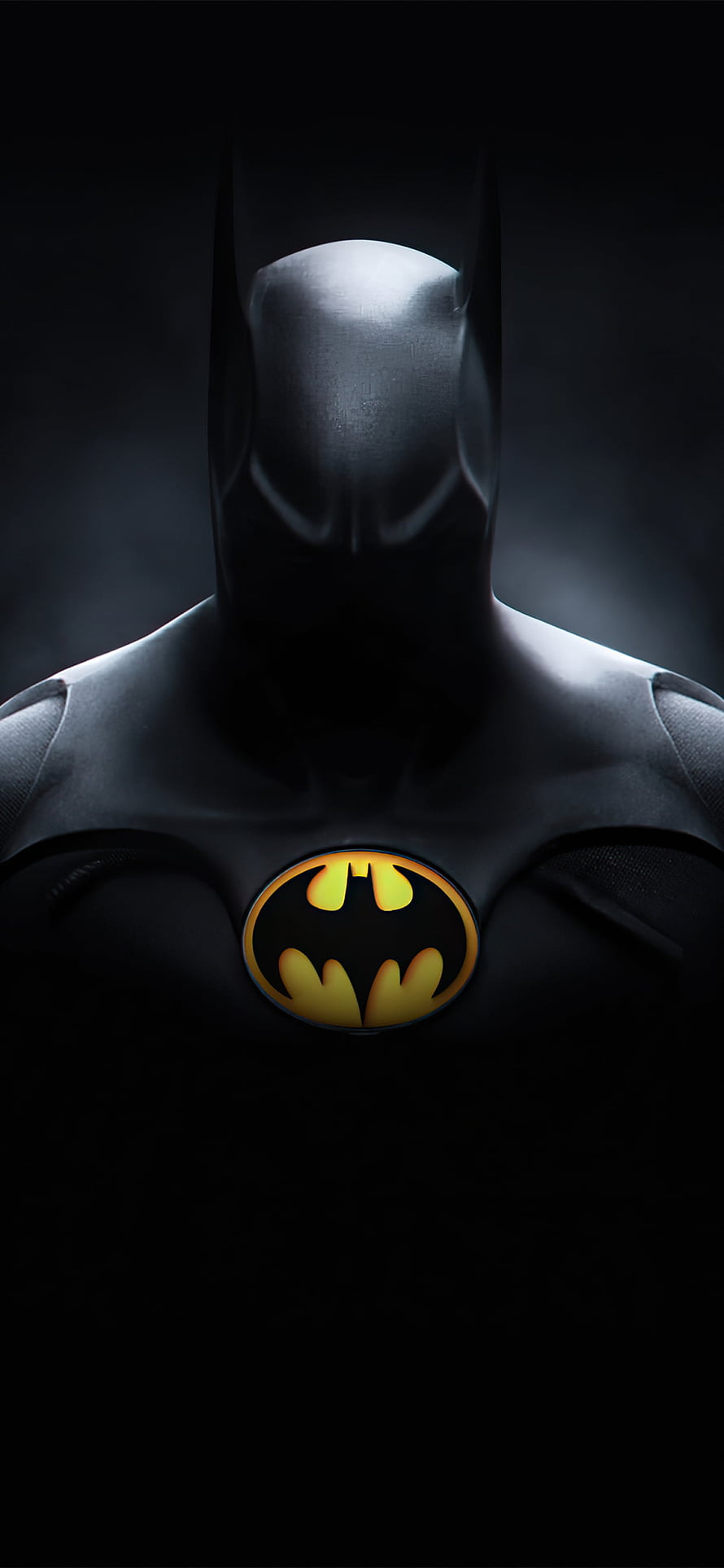 Batman Dark Suit with Glowing Yellow Emblem in Dramatic Shadow HD phone wallpaper