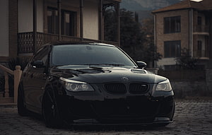 Black BMW E60 M5 Sedan Parked on Cobblestone Driveway at Dusk HD wallpaper