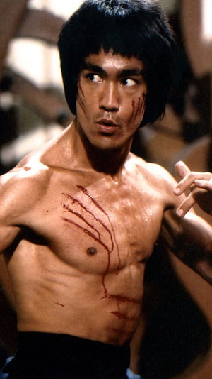 Bruce Lee shirtless with blood streaks in a dramatic martial arts film scene HD phone wallpaper