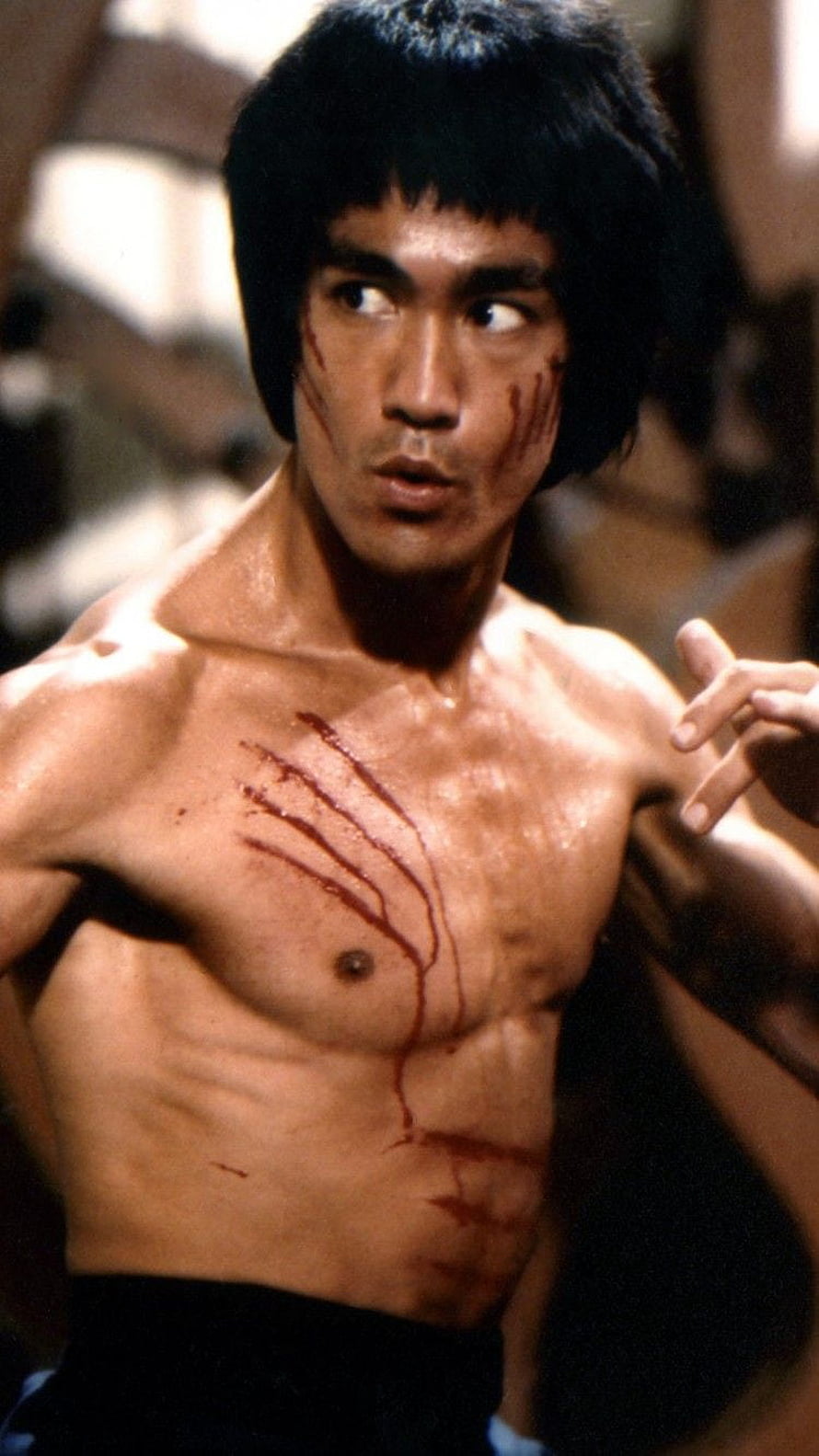 Bruce Lee shirtless with blood streaks in a dramatic martial arts film scene HD phone wallpaper