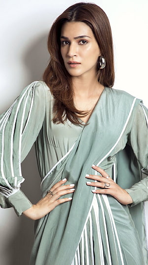 Kriti Sanon in a sage green wrap dress with white piping and statement earrings HD phone wallpaper