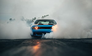 Blue Dodge Challenger SRT Hellcat performing a burnout in thick smoke on an asphalt track HD wallpaper