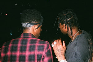Metro Boomin and Travis Scott in a candid nighttime portrait with braids and bandana HD wallpaper