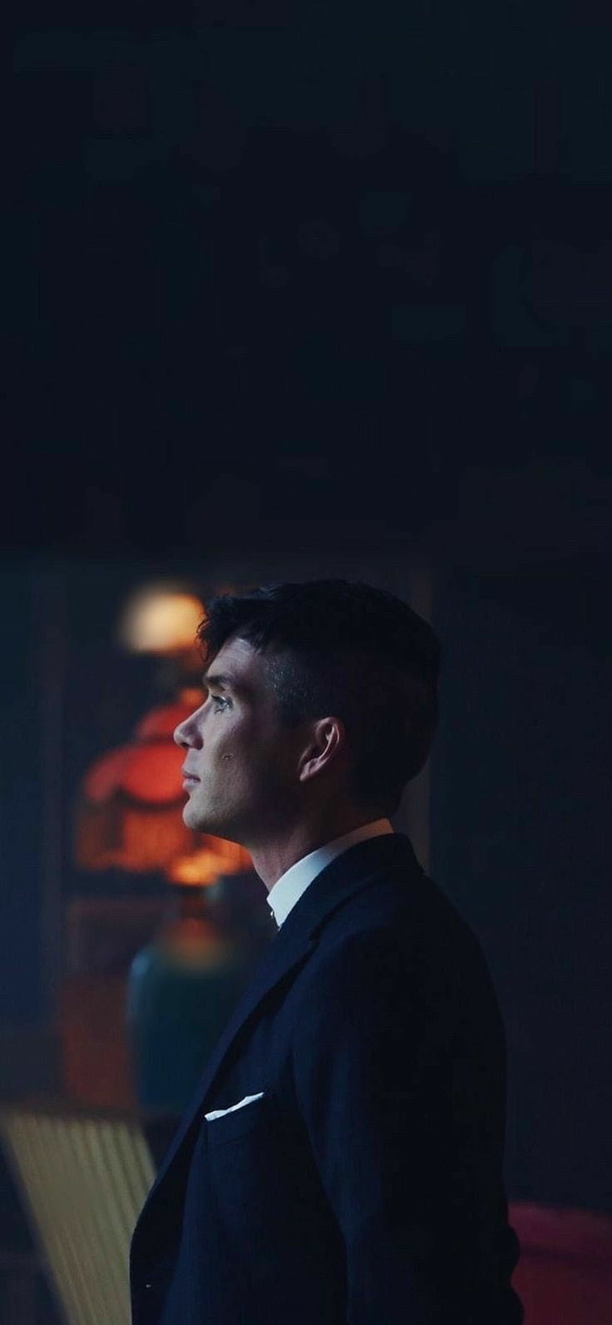 Cillian Murphy in a dark suit from Peaky Blinders, moody cinematic profile portrait with warm bokeh lighting HD phone wallpaper