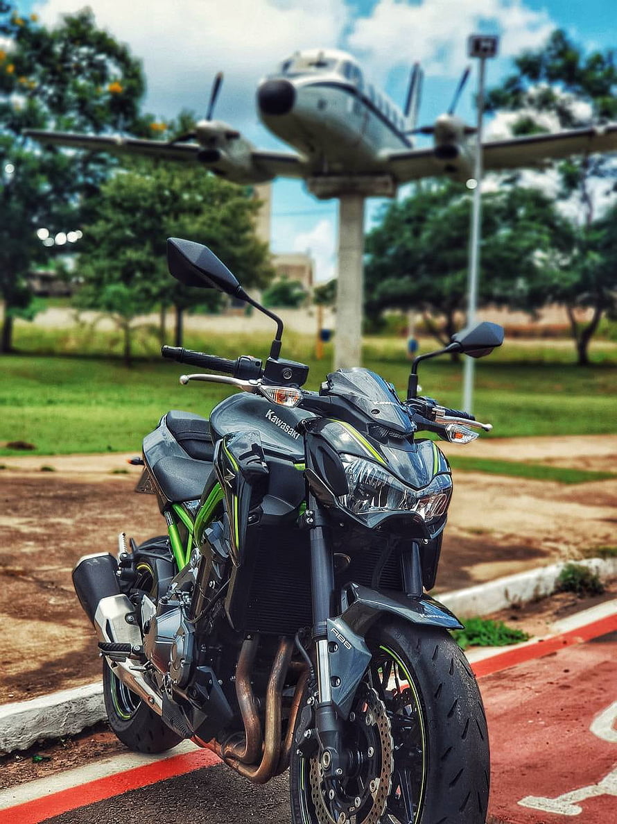 Kawasaki Z900 Motorcycle Parked in Front of a Vintage Propeller Aircraft Display HD phone wallpaper