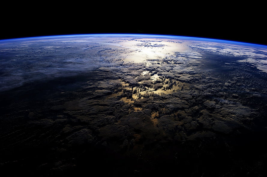 Earth From Space: Dark Ocean Surface With Sunlight Glare and Atmospheric Horizon HD wallpaper