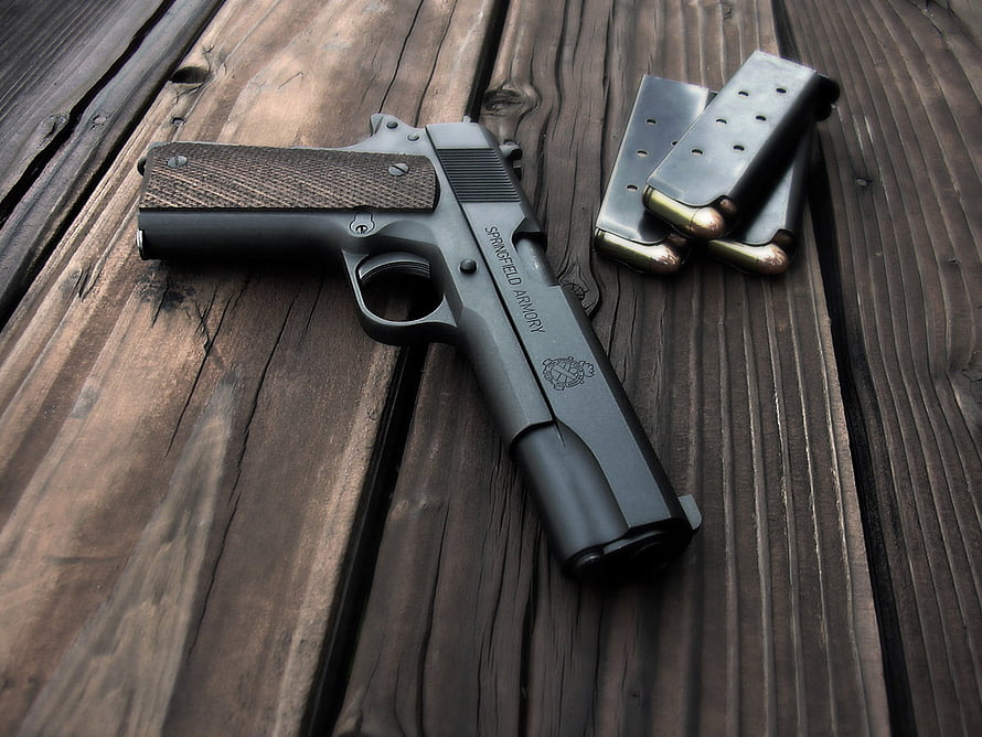 Springfield Armory 1911 Pistol with Loaded Magazine on Weathered Wooden Deck HD wallpaper