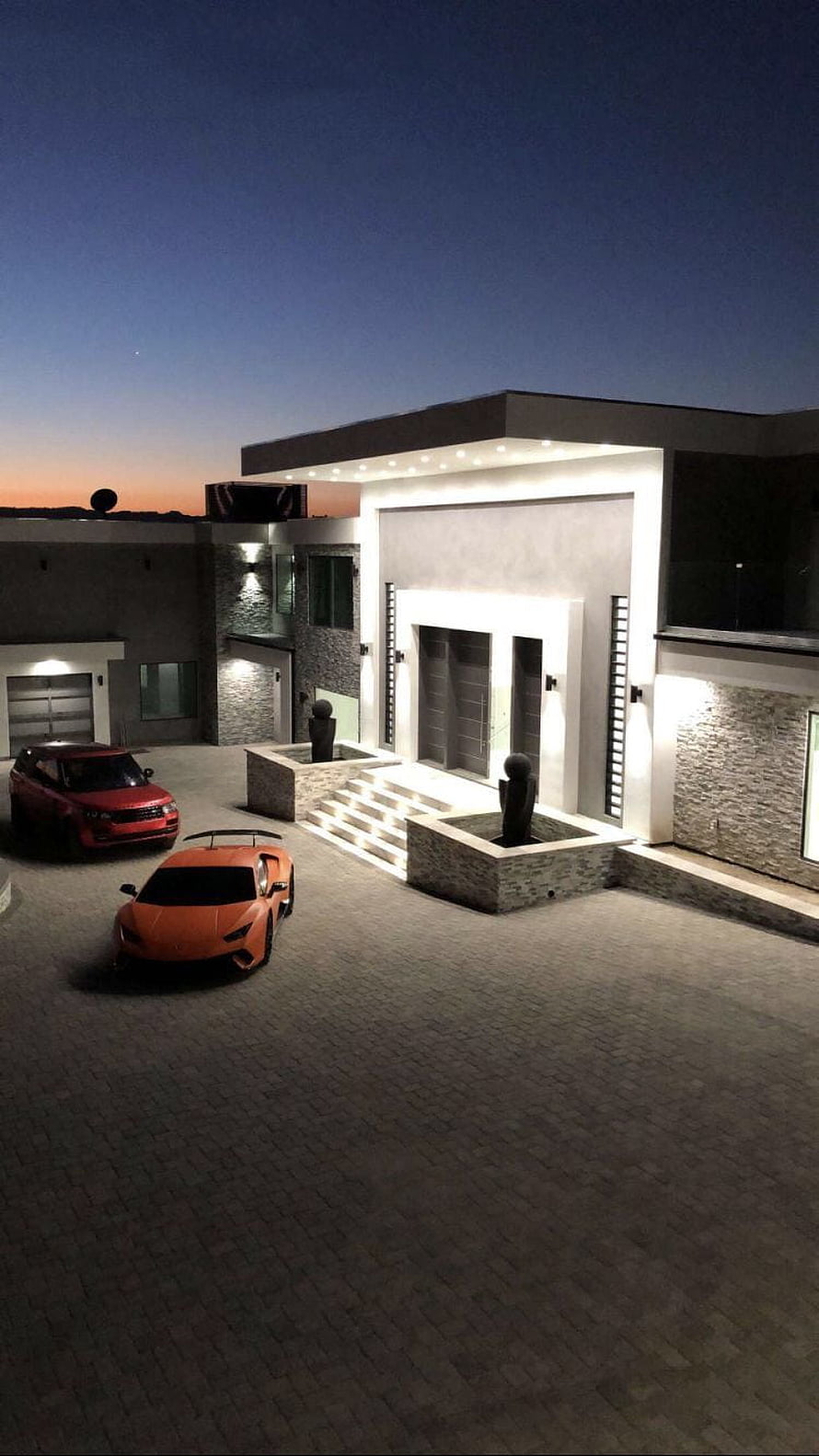 Modern Luxury Villa at Dusk with Orange Lamborghini and Red SUV in Driveway HD phone wallpaper