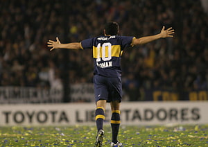 Juan Roman Riquelme celebrating in Boca Juniors kit with arms outstretched on the pitch, Juan Roman Riquelme. Club atlético boca juniors, Boca juniors HD wallpaper