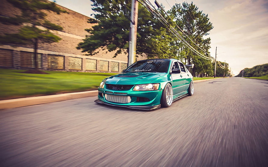 Turquoise Mitsubishi Lancer Evolution 8 drifting on a suburban street with motion blur HD wallpaper