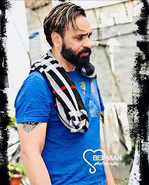 Babbu Maan in a blue t-shirt with a striped scarf draped over his shoulder HD phone wallpaper