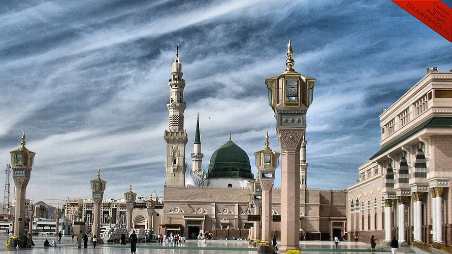 Grand Mosque of Medina with Green Dome and Minarets Under a Cloudy Sky HD wallpaper
