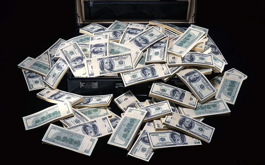 Stacks of US hundred dollar bills spilling from an open black briefcase against a dark background HD wallpaper