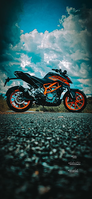 KTM Duke 250 motorcycle parked on asphalt road under dramatic cloudy sky HD phone wallpaper
