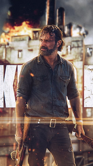 Rick Grimes from The Walking Dead standing before a burning industrial backdrop with weapons in hand HD phone wallpaper