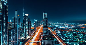 Dubai Cityscape at Night with Illuminated Skyscrapers and Highway Light Trails HD wallpaper