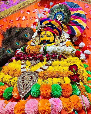 Khatu Shyam deity adorned with vibrant marigold garlands and peacock feathers HD phone wallpaper