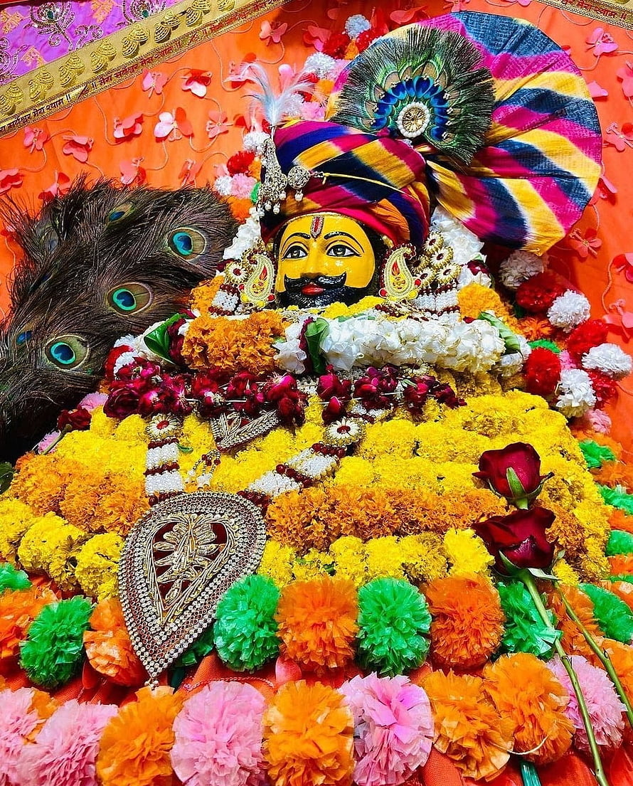 Khatu Shyam deity adorned with vibrant marigold garlands and peacock feathers HD phone wallpaper