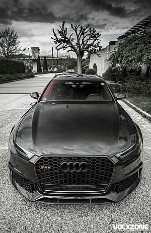 Front View of a Black Carbon Fiber Audi RS6 Avant Parked on Gravel Under a Dramatic Sky HD phone wallpaper