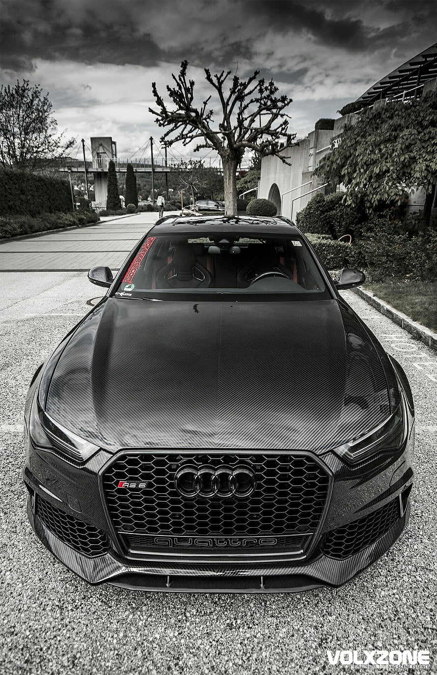 Front View of a Black Carbon Fiber Audi RS6 Avant Parked on Gravel Under a Dramatic Sky HD phone wallpaper