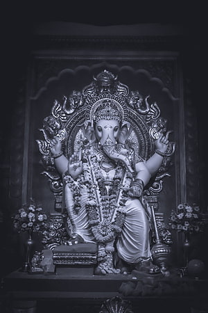 Ganesha Temple Idol in Black and White with Floral Garland and Ornate Carvings HD phone wallpaper