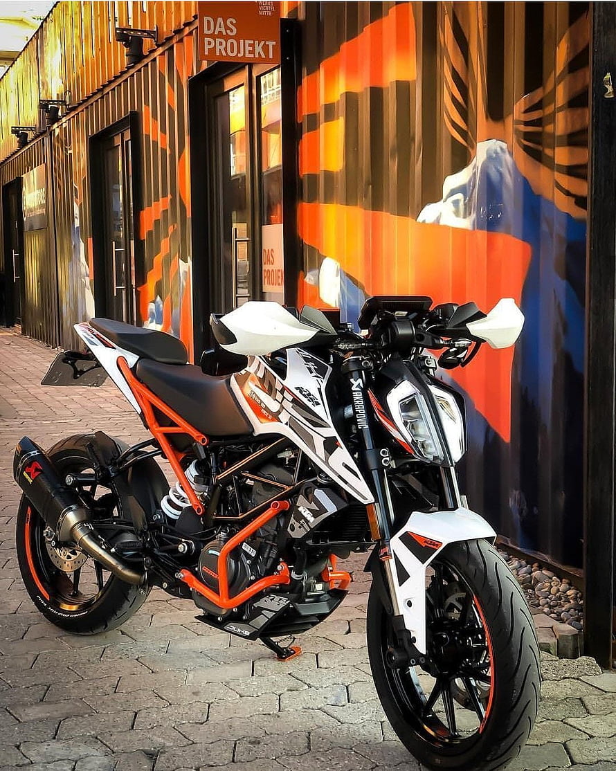 White and Orange KTM RC 200 Sport Motorcycle Parked on Cobblestone Street HD phone wallpaper