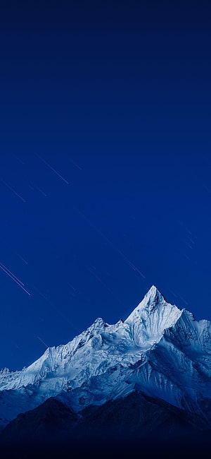 Snow-Capped Mountain Peak Under Deep Blue Night Sky with Star Trails HD phone wallpaper