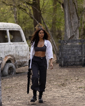 Sonam Bajwa in Action Scene with Rifle and Rusted Van in Forest HD phone wallpaper