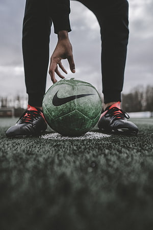 Nike Soccer Ball on Artificial Turf with Black and Red Cleats HD phone wallpaper
