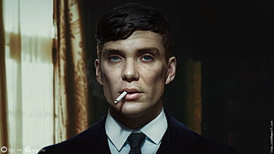 Tommy Shelby in a dark suit with a cigarette, intense portrait from Peaky Blinders HD wallpaper