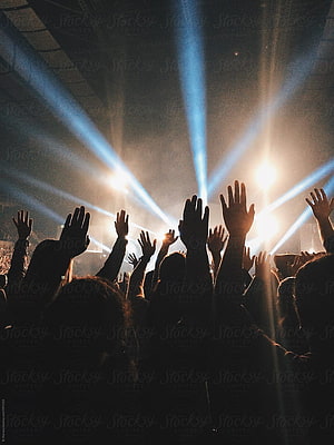 Silhouetted Crowd With Raised Hands Under Bright Stage Lights at a Live Worship Concert HD phone wallpaper