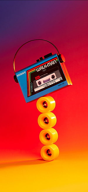 Retro Sony Walkman Balanced on Yellow Skateboard Wheels Against Vibrant Gradient Background HD phone wallpaper
