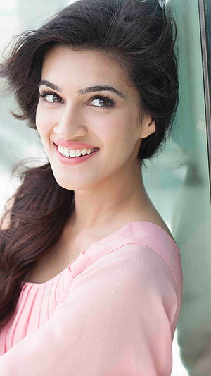 Kriti Sanon smiling portrait in a soft pink blouse with long dark hair HD phone wallpaper