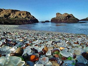 Colorful Sea Glass Beach with Rocky Headlands and Clear Blue Water HD wallpaper