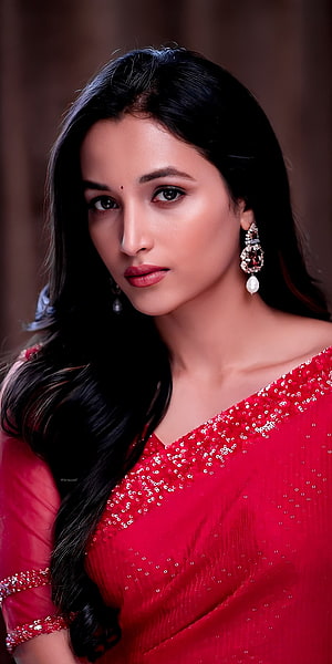 Srinidhi Shetty in a red sequined saree with ornate earrings and long dark hair HD phone wallpaper
