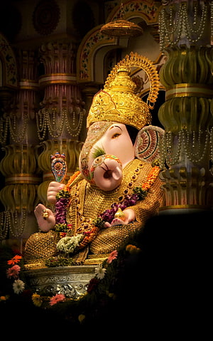 Ornate Golden Ganpati Murti Adorned with Marigold Garlands in a Decorated Temple Shrine HD phone wallpaper